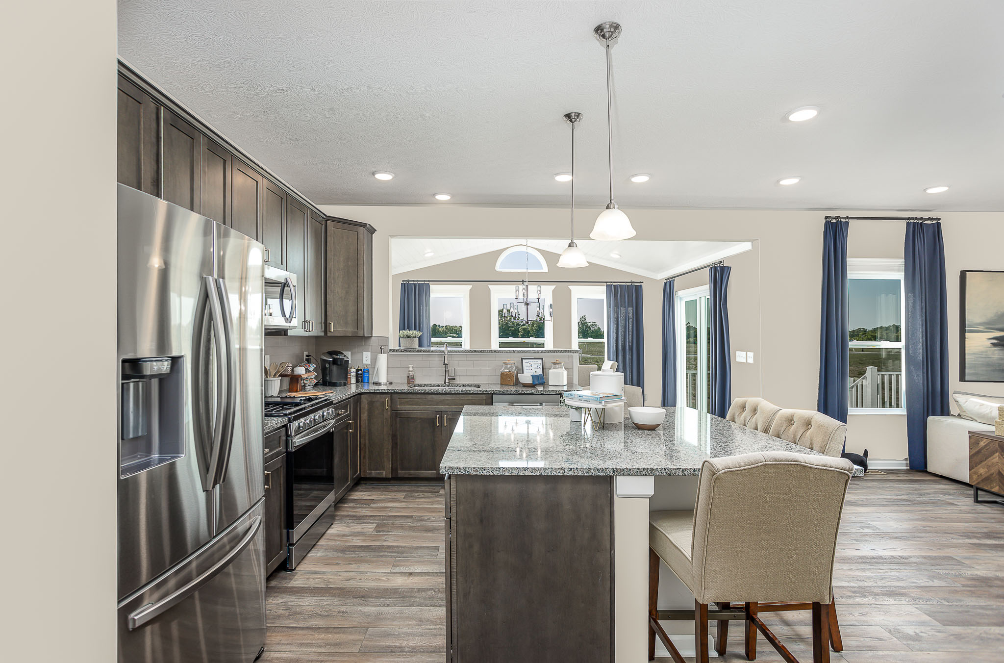 Modern kitchen with eat-in island in a new home for sale in Sarver