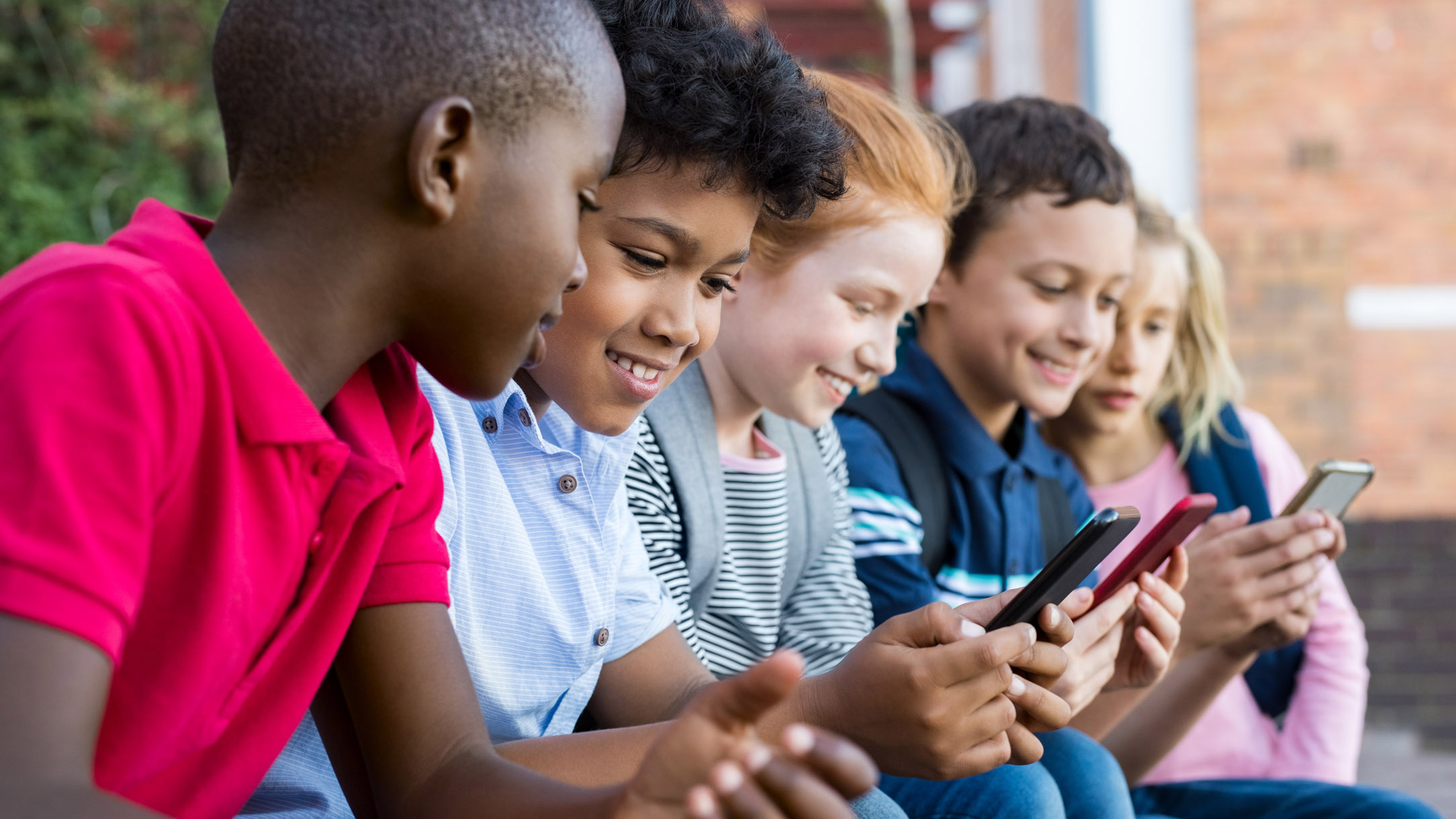 Five children viewing cellphones