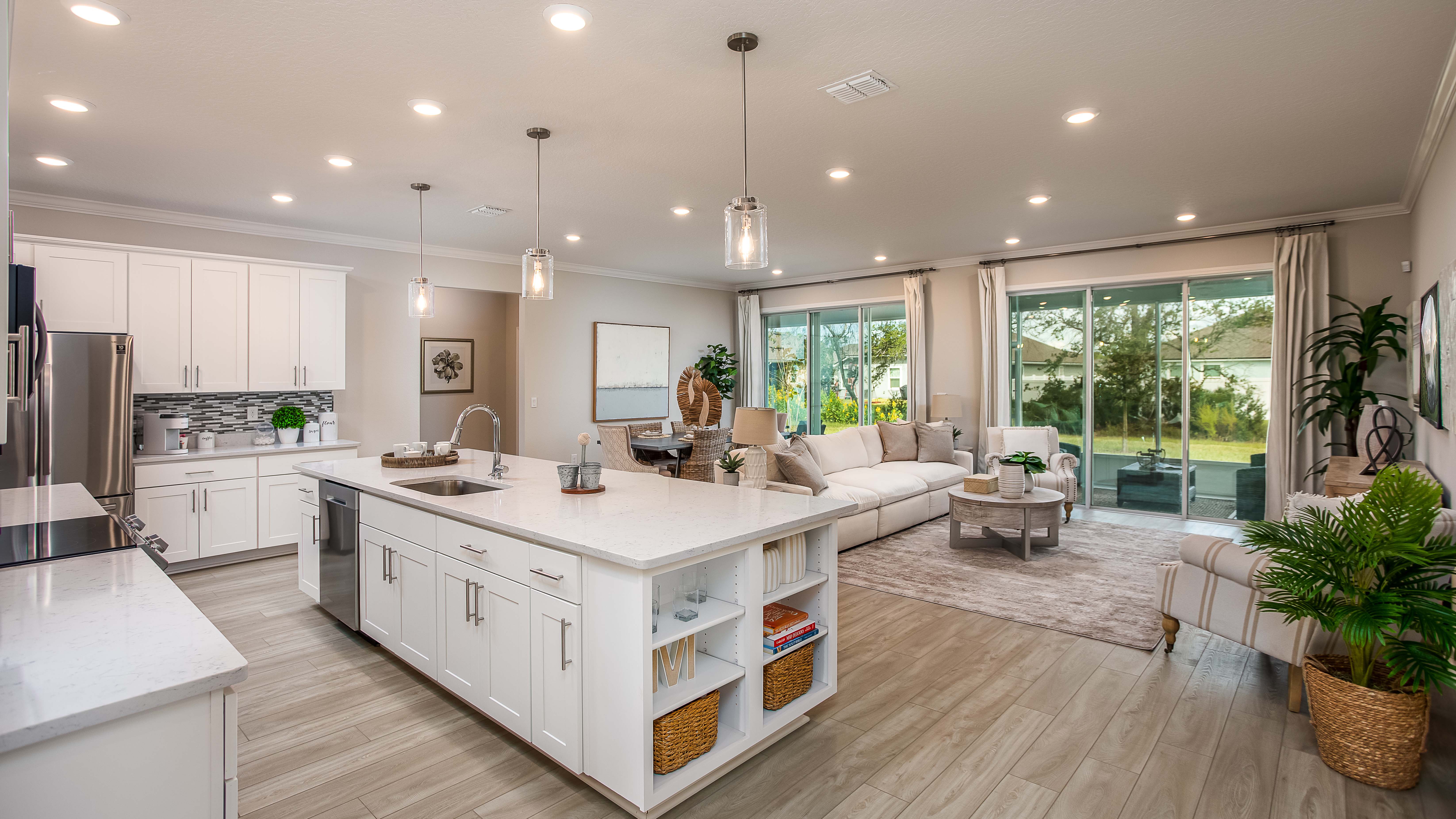 white cabinet kitchen with natural stone countertops into livingroom in a new home in merritt island, fl